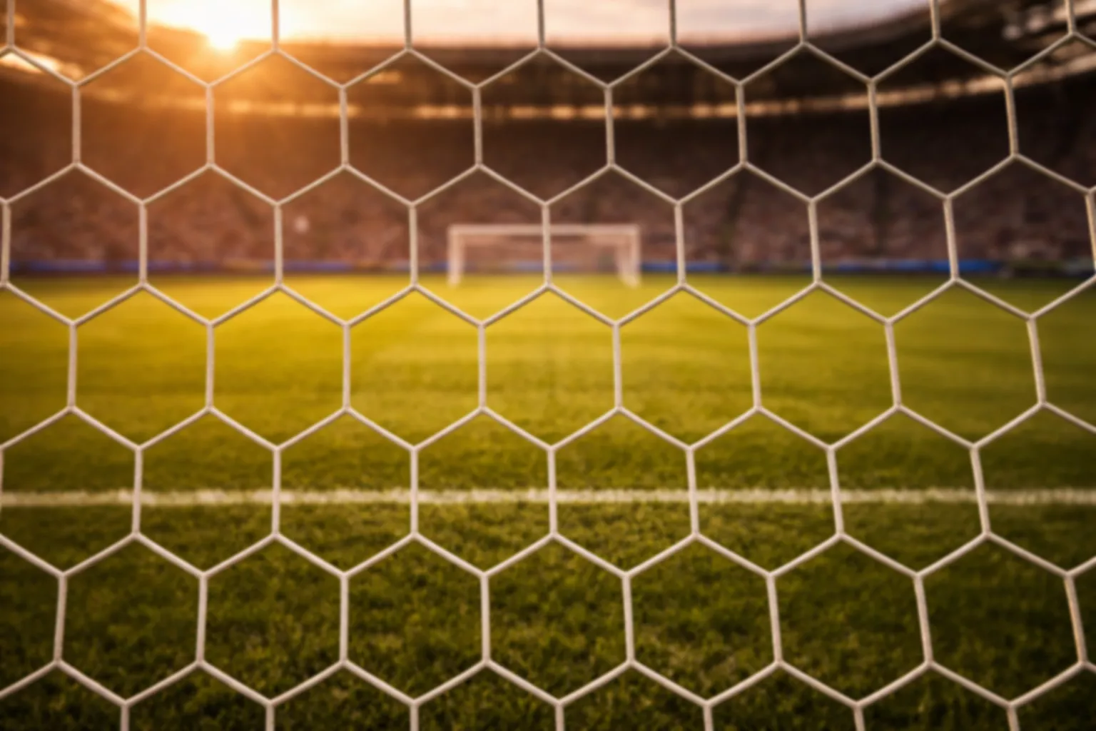 Rete di una porta da calcio vista da vicino con il campo verde sullo sfondo
